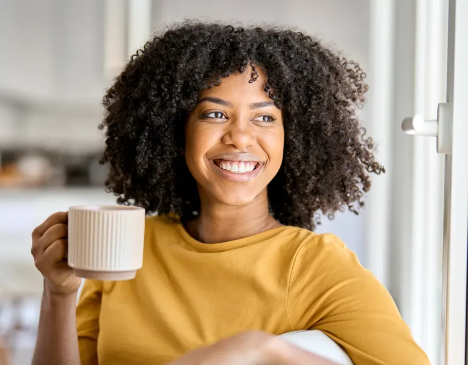 Smiling woman relaxing at home with a cup of coffee